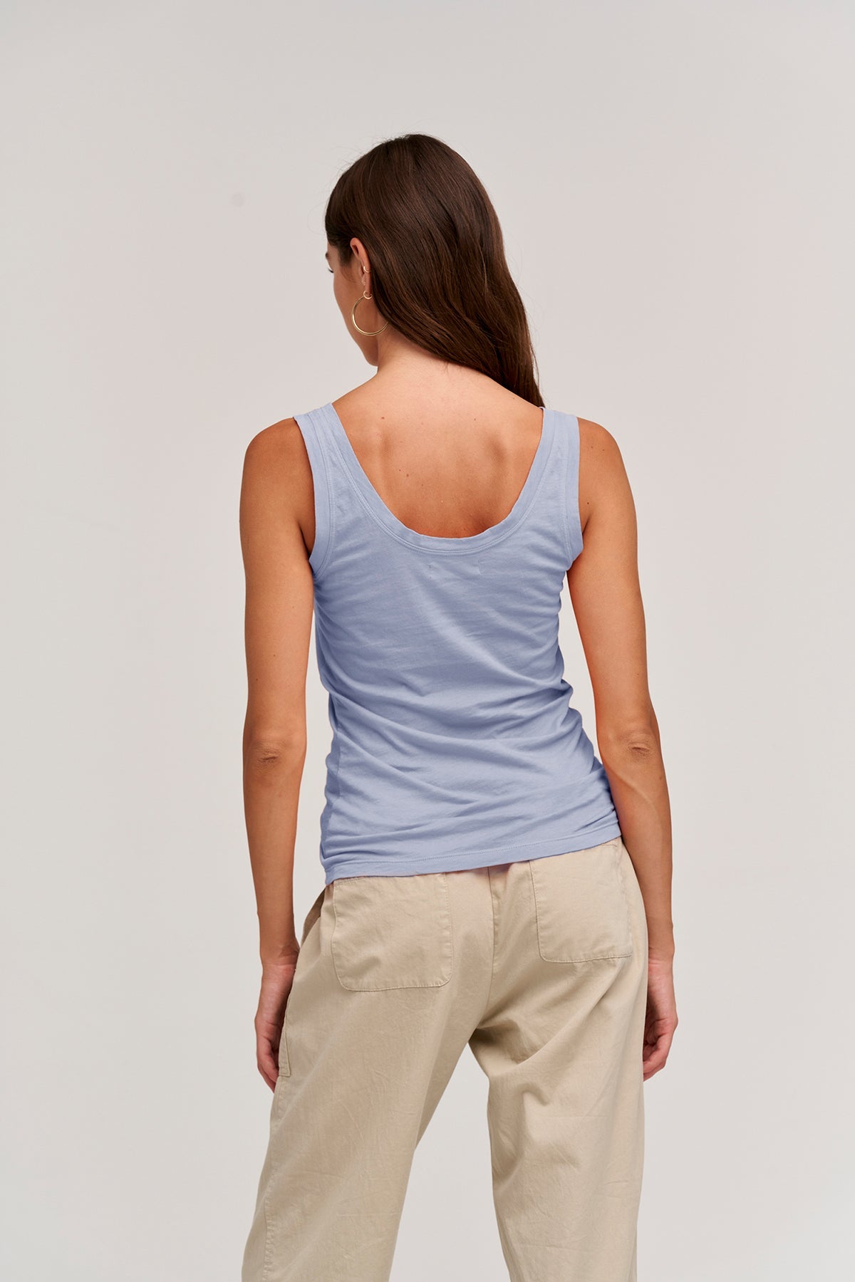   a woman wearing a Velvet by Graham & Spencer MOSSY GAUZY WHISPER FITTED TANK and khaki pants. 
