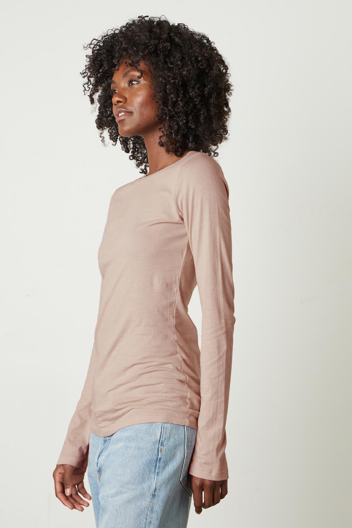   A woman wearing a Velvet by Graham & Spencer ZOFINA GAUZY WHISPER FITTED CREW NECK TEE-perfection and jeans. 
