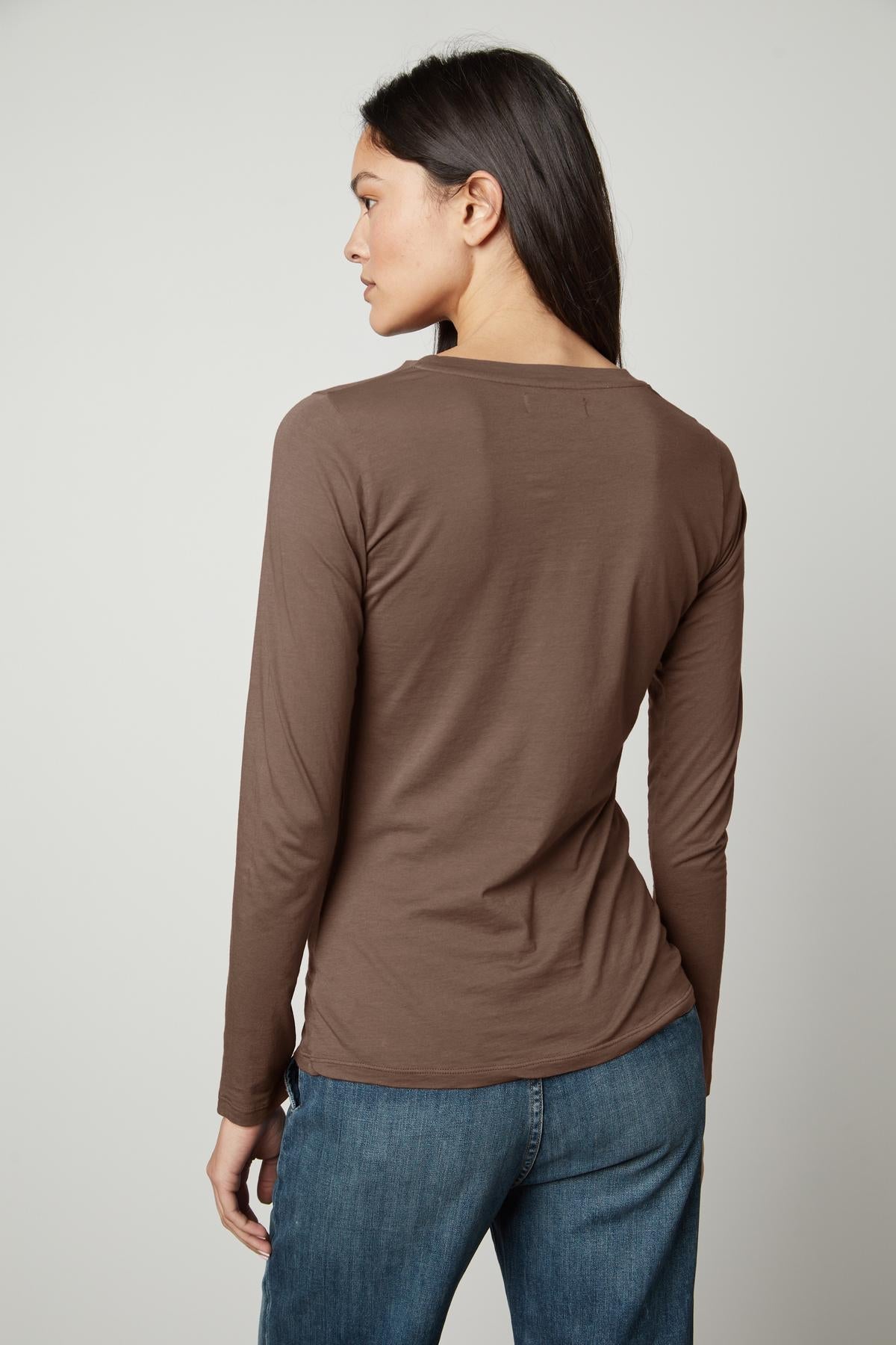 The back view of a woman wearing a Velvet by Graham & Spencer ZOFINA GAUZY WHISPER FITTED CREW NECK TEE.-35783262404801