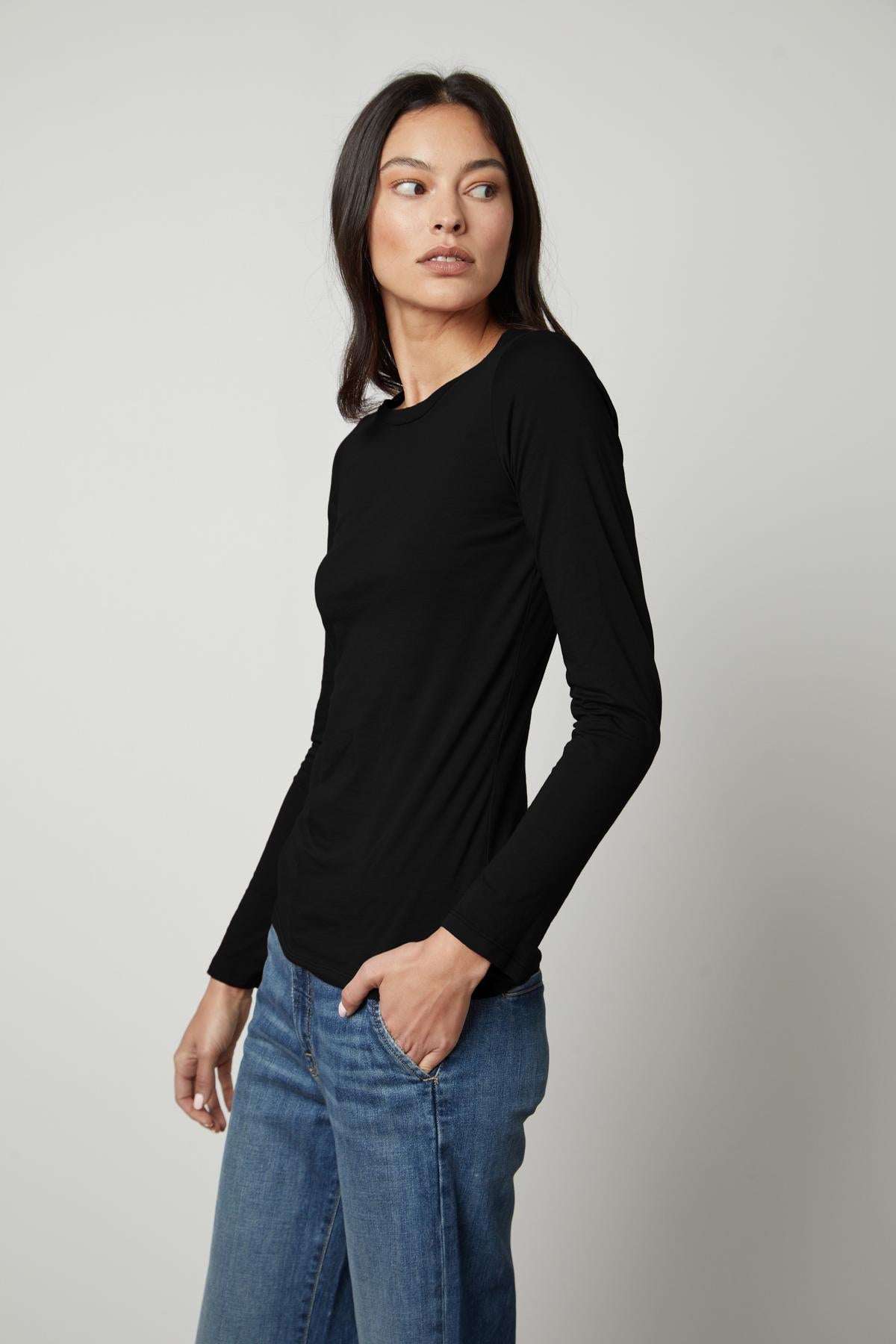 A woman in a ZOFINA GAUZY WHISPER FITTED CREW NECK TEE by Velvet by Graham & Spencer and jeans.-35503491154113