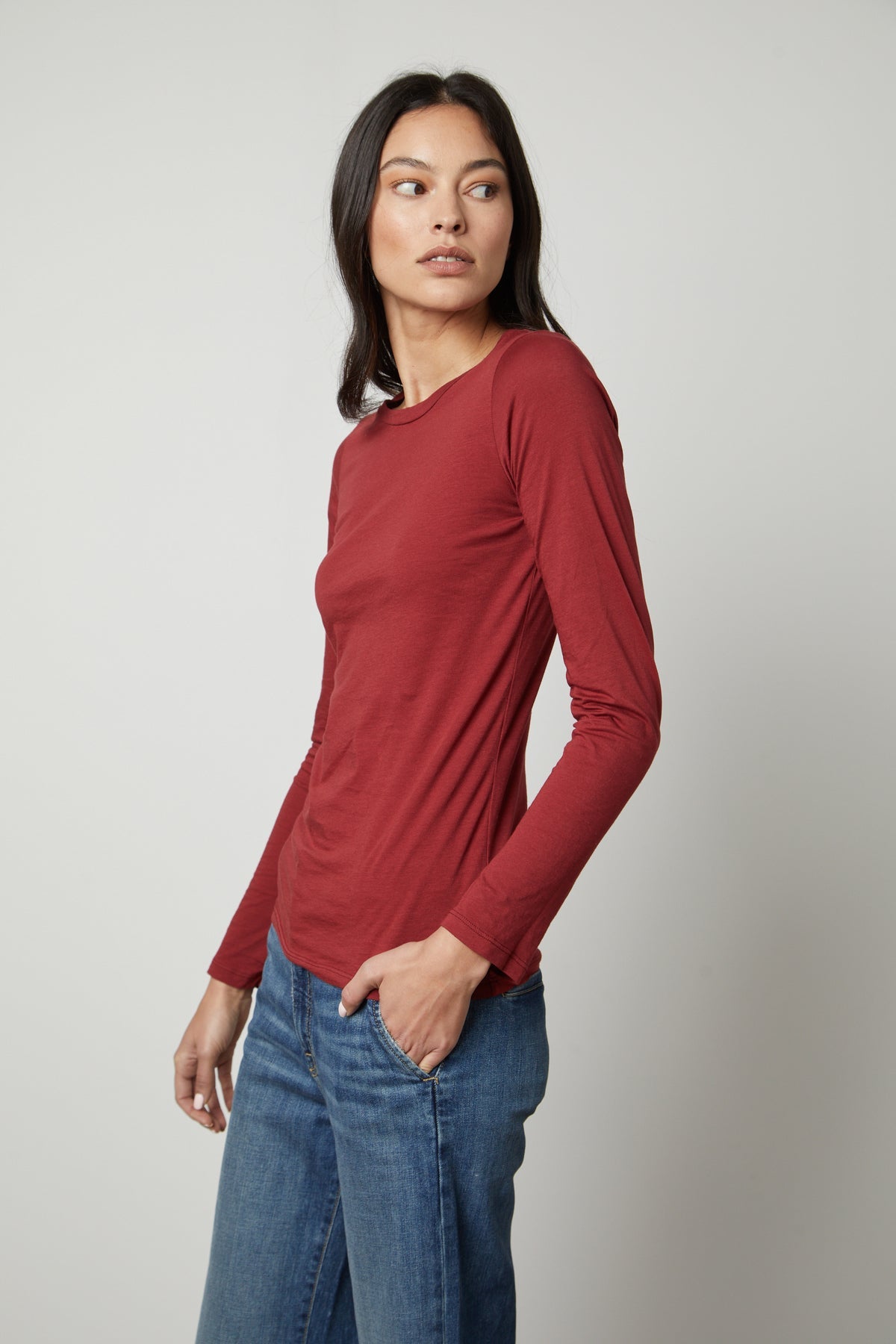   The model is wearing a red long-sleeved ZOFINA GAUZY WHISPER FITTED CREW NECK TEE by Velvet by Graham & Spencer. 