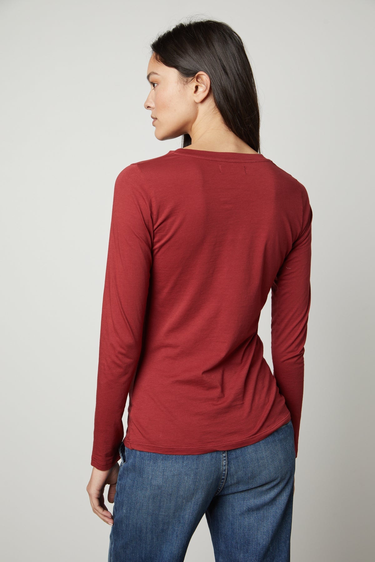 The back view of a woman wearing a red Velvet by Graham & Spencer ZOFINA GAUZY WHISPER FITTED CREW NECK TEE.-35783263224001