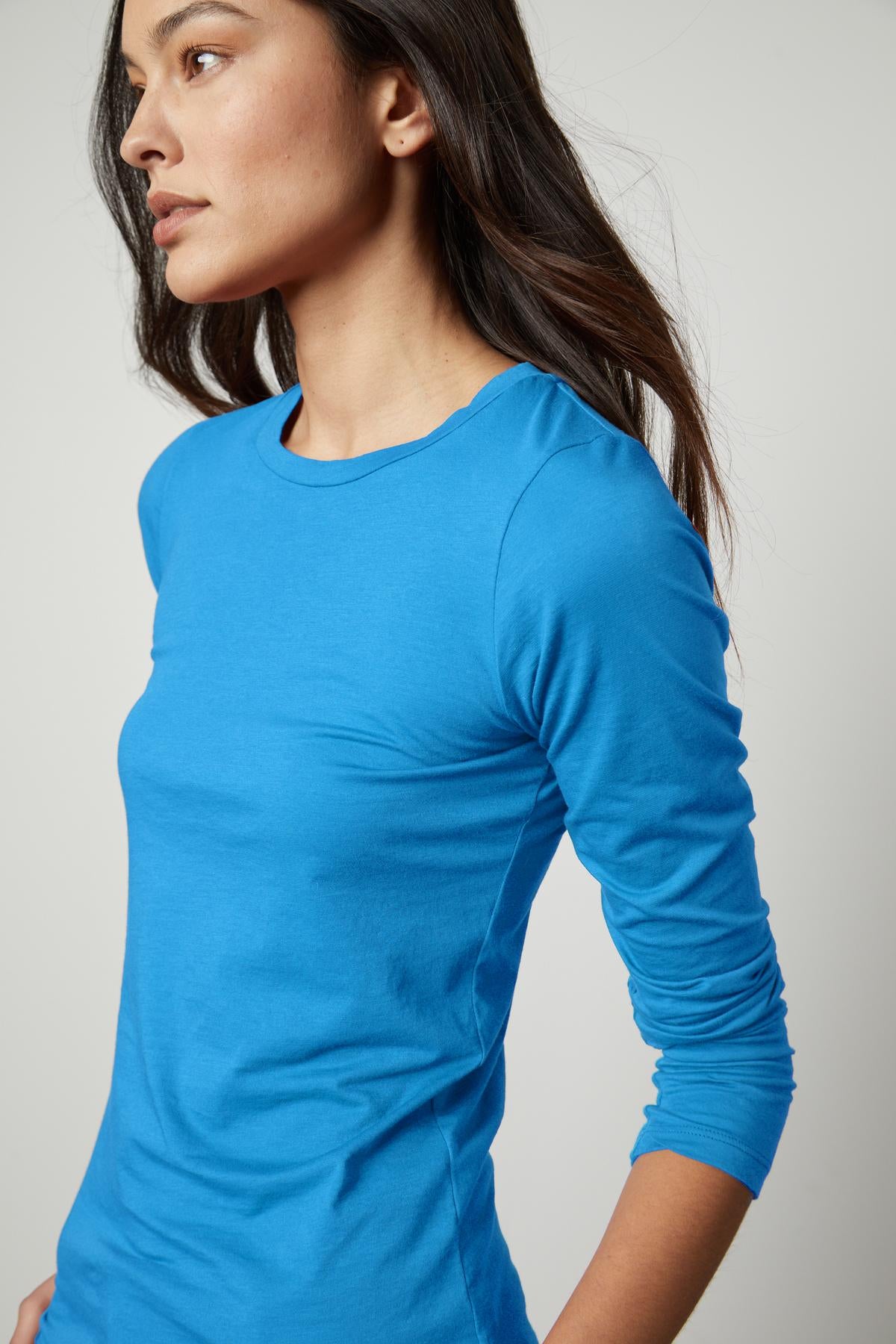 A woman wearing a Velvet by Graham & Spencer ZOFINA GAUZY WHISPER FITTED CREW NECK TEE-perfection.-35503495315649