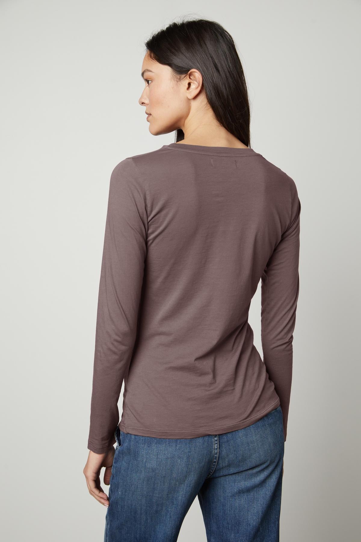 The back view of a woman wearing Velvet by Graham & Spencer jeans and the ZOFINA GAUZY WHISPER FITTED CREW NECK TEE in a universally flattering cut.-35503498952897