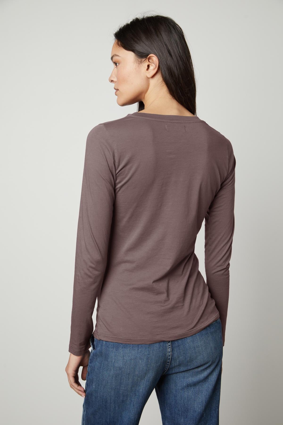   The back view of a woman wearing Velvet by Graham & Spencer jeans and the ZOFINA GAUZY WHISPER FITTED CREW NECK TEE in a universally flattering cut. 