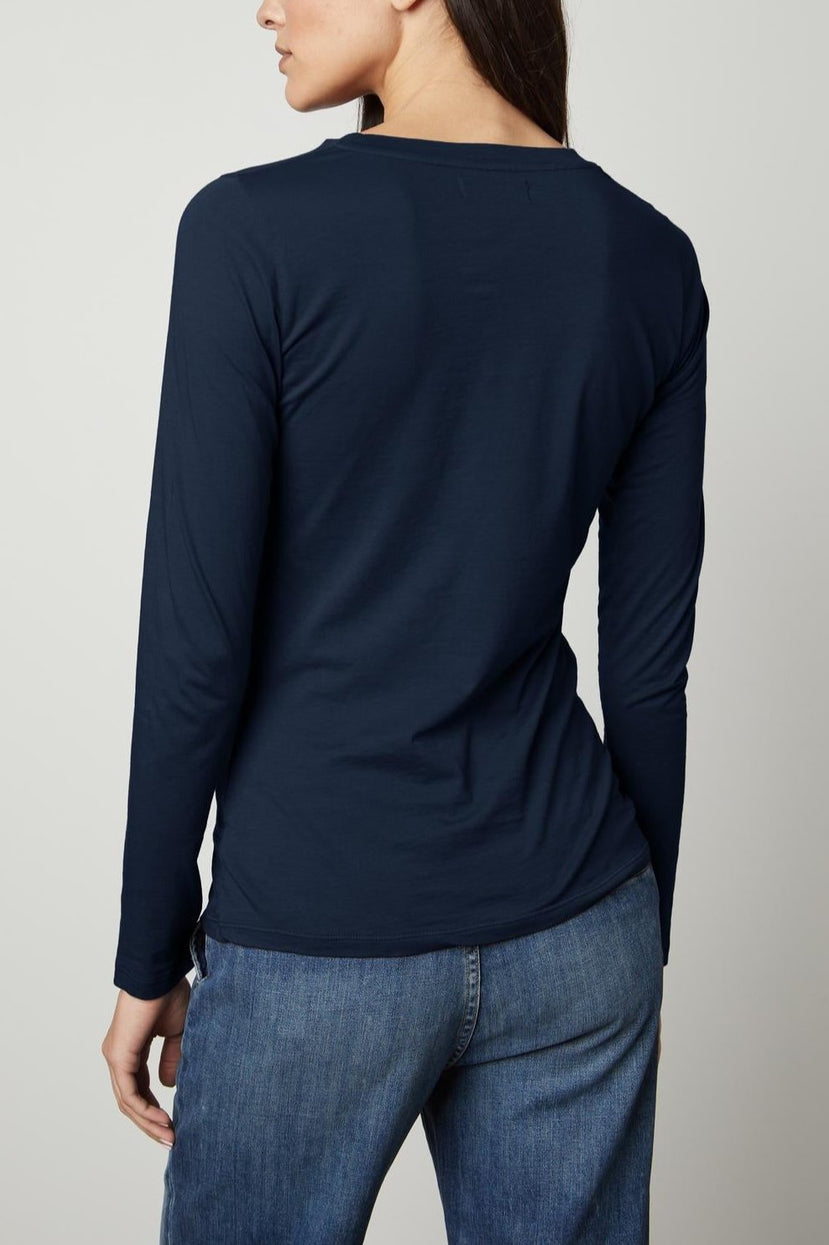 The back view of a woman wearing jeans and a Velvet by Graham & Spencer ZOFINA GAUZY WHISPER FITTED CREW NECK TEE.