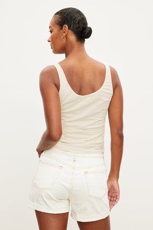 The back view of a woman wearing white shorts and a Velvet by Graham & Spencer DRUCIE SCOOP NECK TANK TOP.