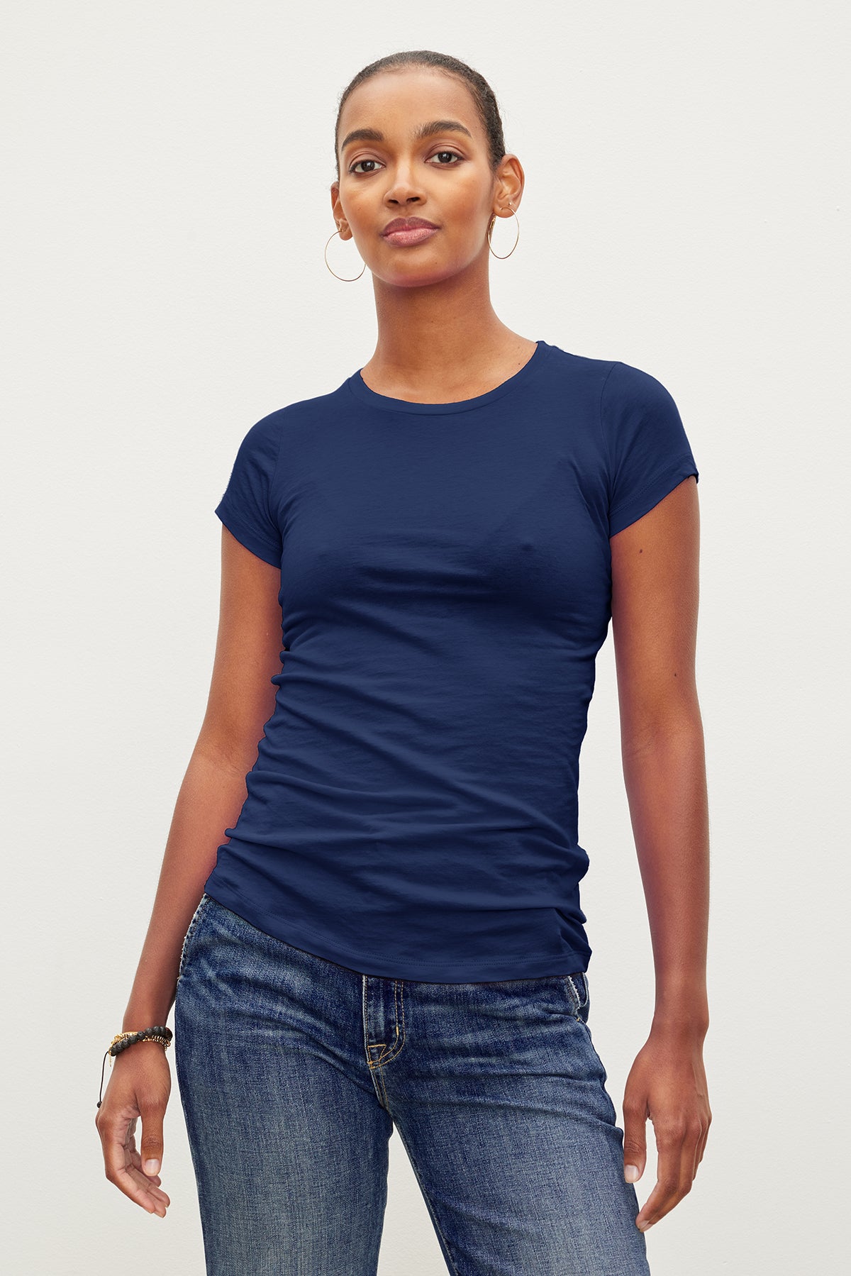 A person wearing a JEMMA GAUZY WHISPER FITTED CREW NECK TEE by Velvet by Graham & Spencer and jeans.-35571890782401