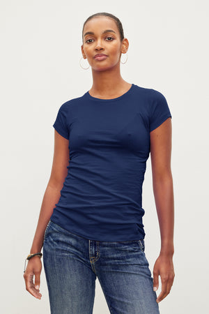 A person wearing a JEMMA GAUZY WHISPER FITTED CREW NECK TEE by Velvet by Graham & Spencer and jeans.