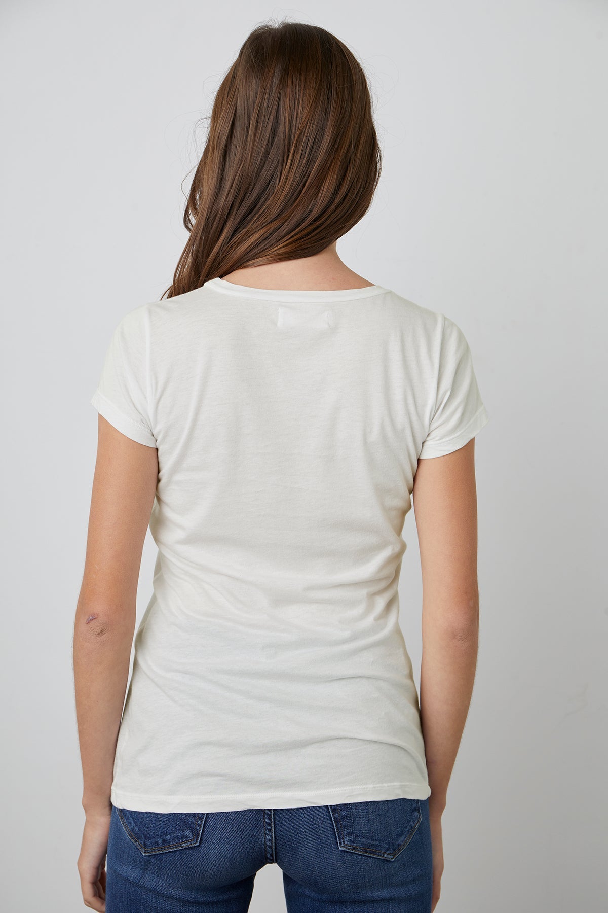 the back view of a woman wearing a Velvet by Graham & Spencer JEMMA GAUZY WHISPER FITTED CREW NECK TEE.-26630463357121