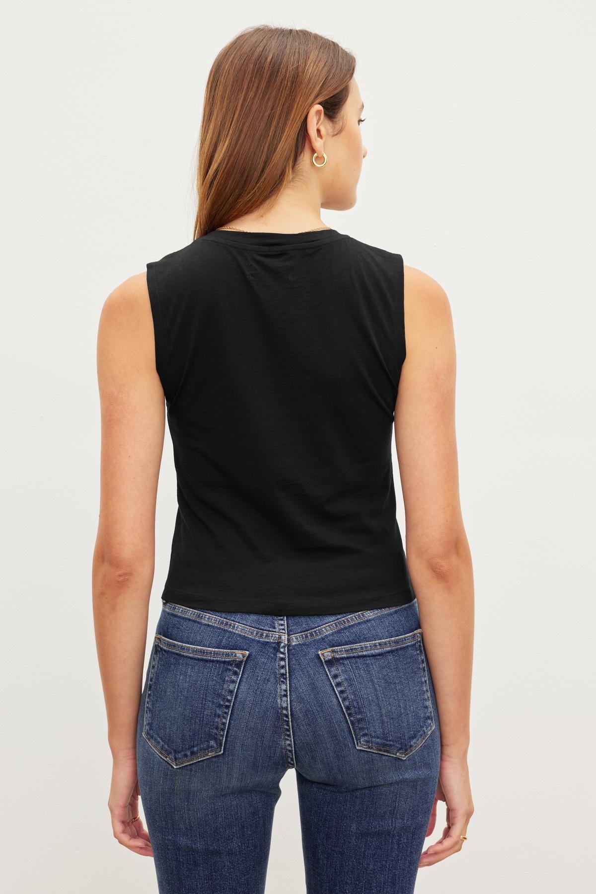 A woman from behind wearing a MAGSON CREW NECK TANK TOP by Velvet by Graham & Spencer and blue jeans.-36418284486849