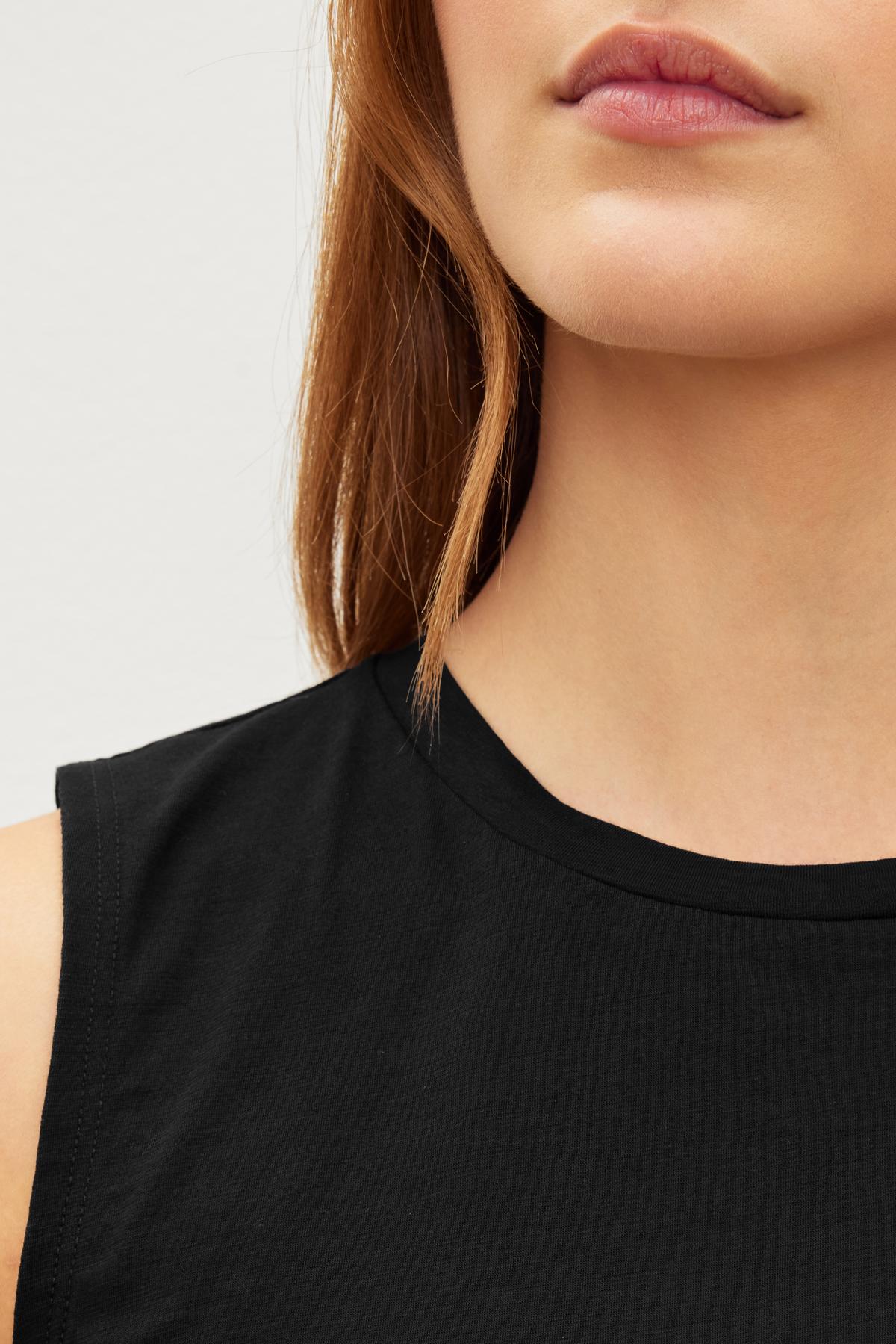 Close-up of a woman's lower face and shoulder, showing her lips and Velvet by Graham & Spencer MAGSON CREW NECK TANK TOP.-36426074751169