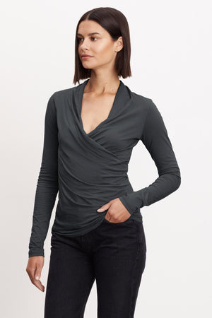 A woman wearing a Velvet by Graham & Spencer MERI WRAP FRONT FITTED TOP, a grey long-sleeved top with a slight crossover v-neck.