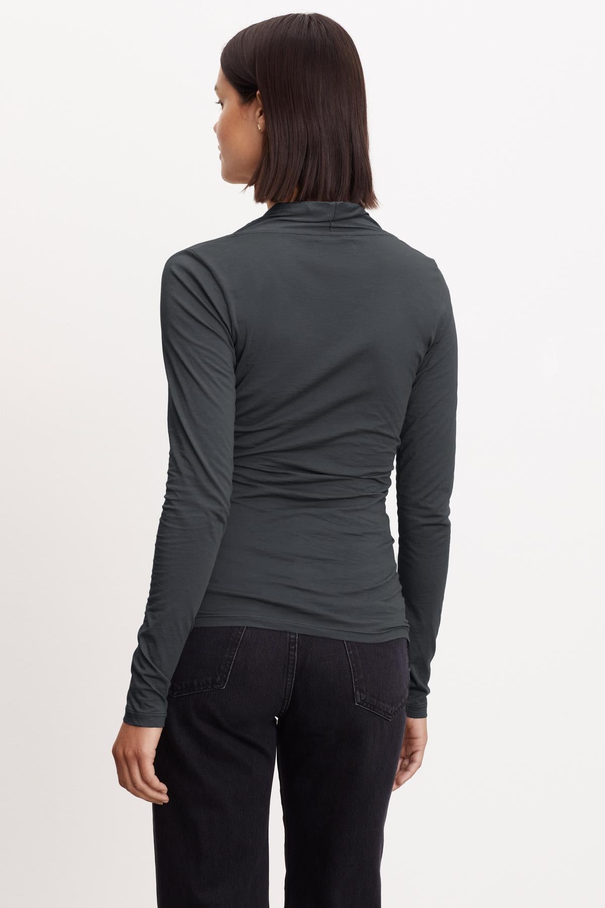 The back view of a woman wearing a Velvet by Graham & Spencer MERI WRAP FRONT FITTED TOP.-35783009861825