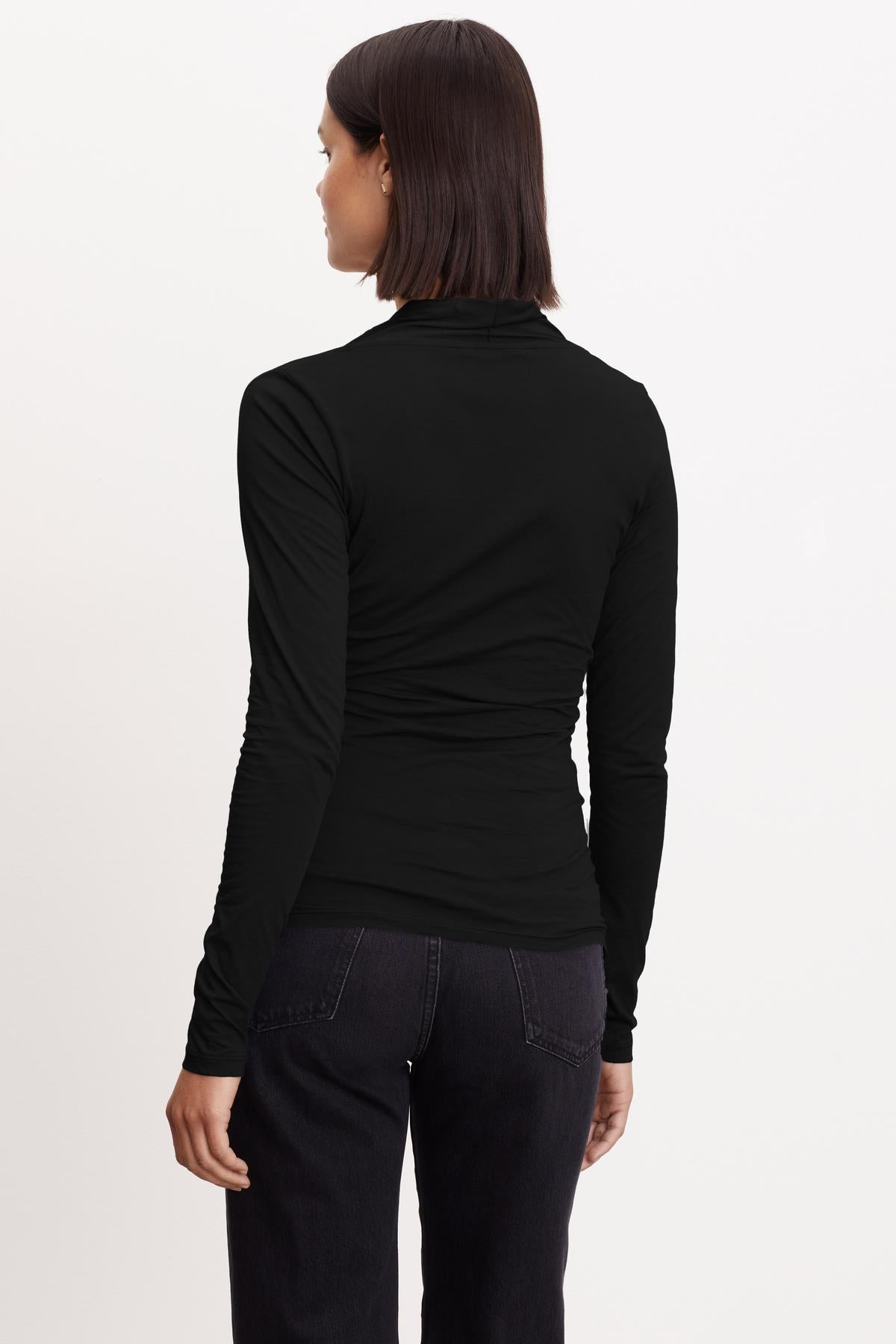 The back view of a woman wearing a Velvet by Graham & Spencer MERI WRAP FRONT FITTED TOP with clean lines.-26921359442113