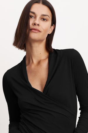 A woman wearing a Velvet by Graham & Spencer MERI WRAP FRONT FITTED TOP with clean lines.
