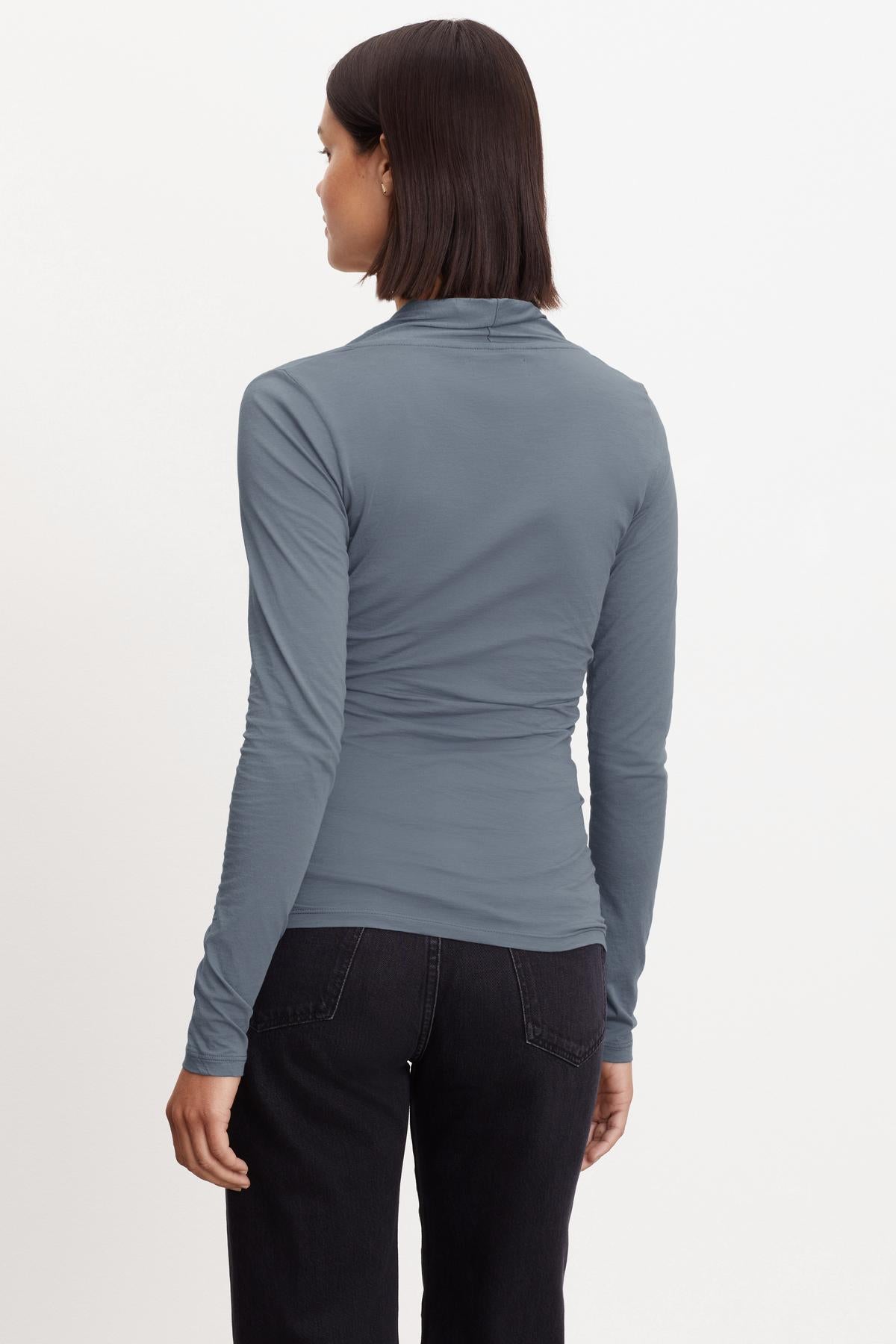 The back view of a woman wearing a Velvet by Graham & Spencer MERI WRAP FRONT FITTED TOP.-36094410621121