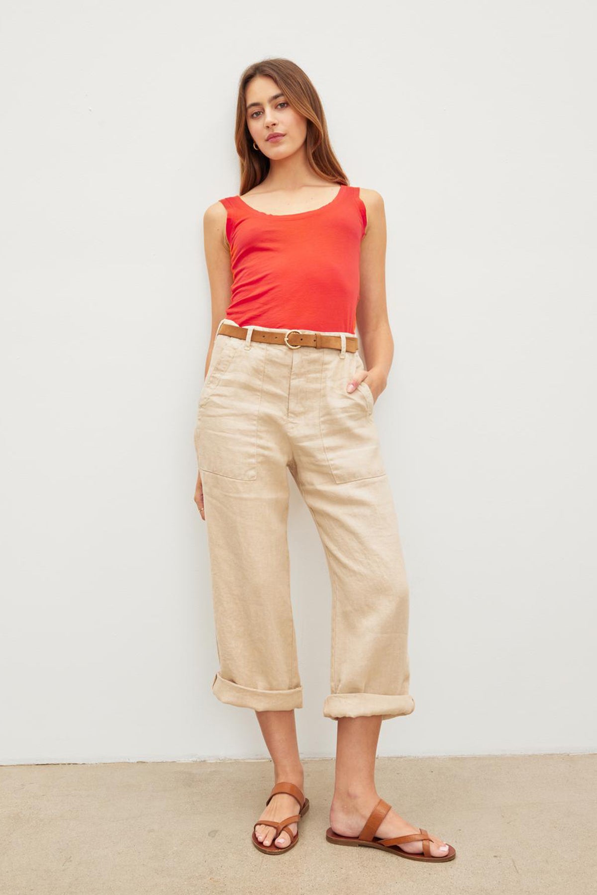   The model is wearing a red Velvet by Graham & Spencer MOSSY GAUZY WHISPER FITTED TANK and tan cropped pants. 