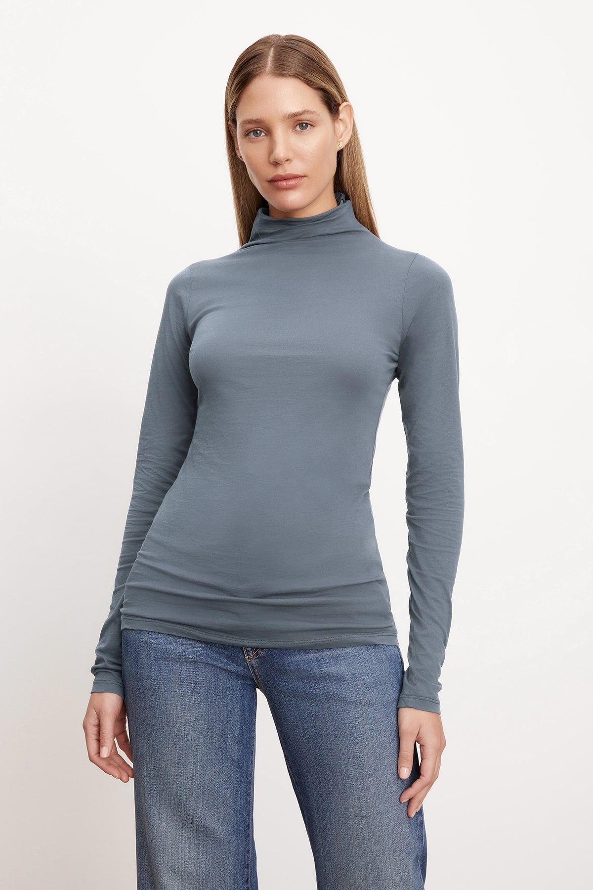 A woman wearing a Velvet by Graham & Spencer TALISIA GAUZY WHISPER FITTED MOCK NECK TEE and jeans.-36001491484865