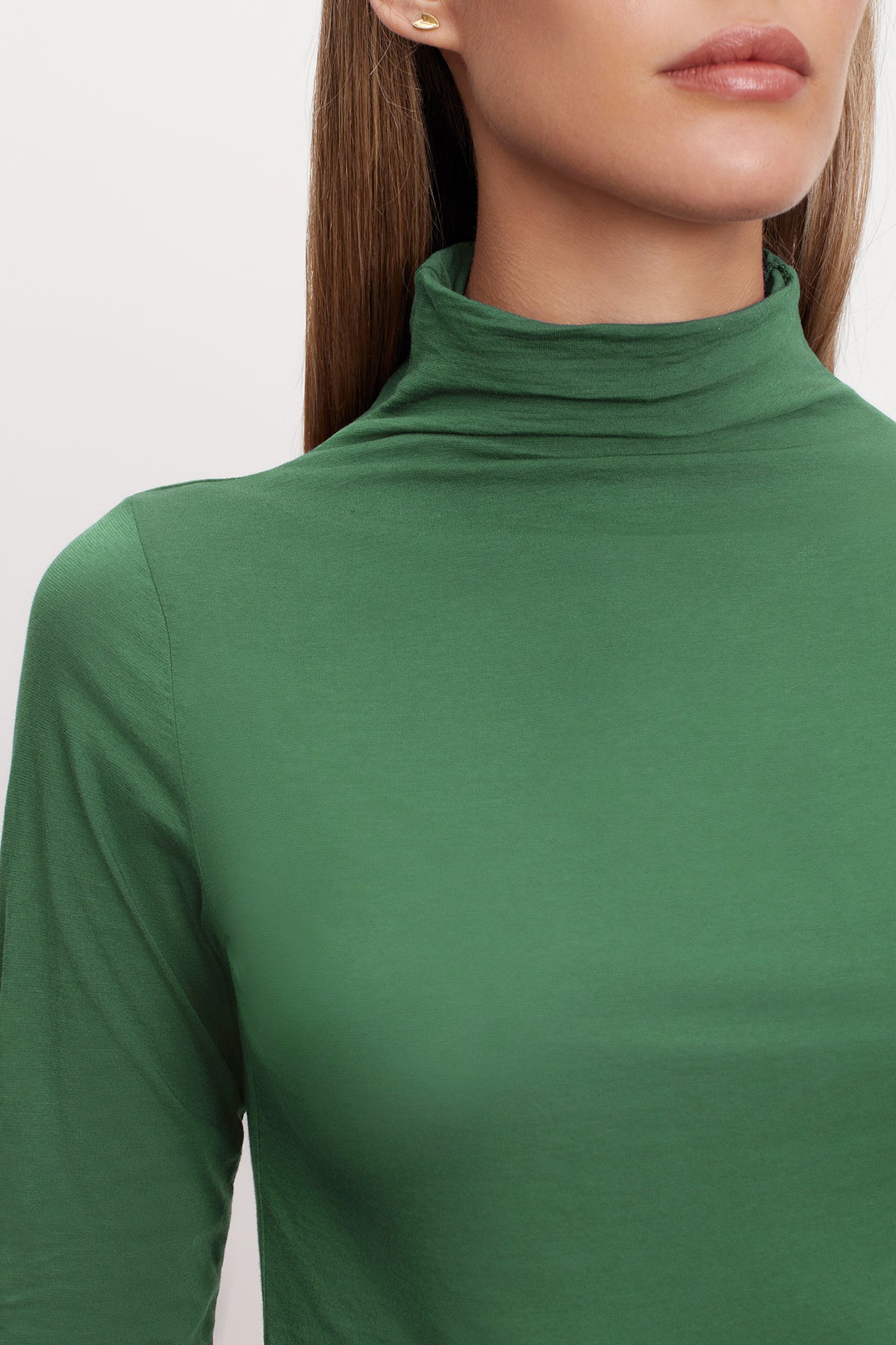 A woman rocking a green Velvet by Graham & Spencer TALISIA GAUZY WHISPER FITTED MOCK NECK TEE, a wardrobe staple in the fashion world.-36001491452097