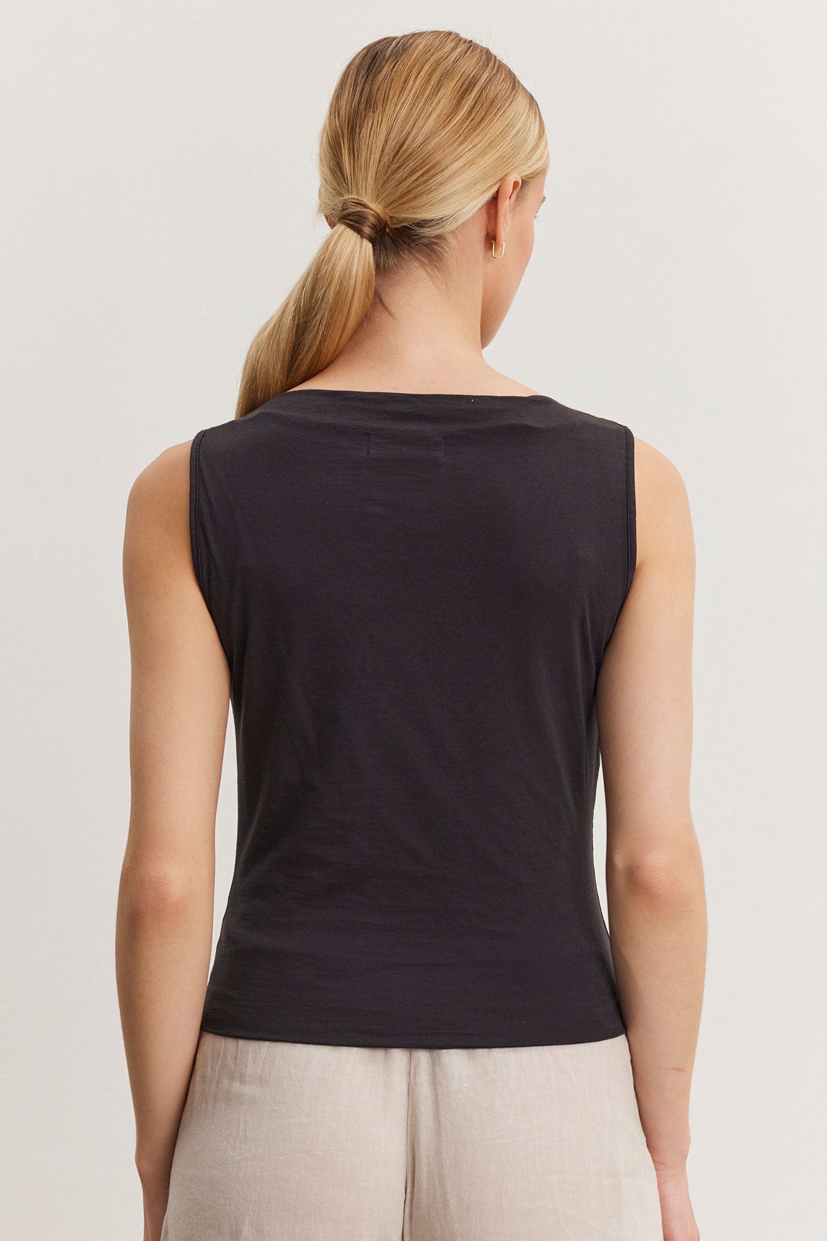   Woman wearing an Emilia tank top by Velvet by Graham & Spencer, viewed from the back, with a ponytail hairstyle. 