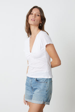 The model is wearing a Velvet by Graham & Spencer HEIDI V-NECK TEE and denim shorts.