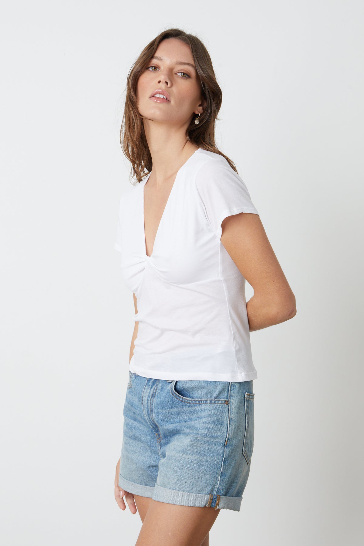 The model is wearing a white t-shirt and Velvet by Graham & Spencer's NATALIE ROLLED HEM SHORT.-26484786168001