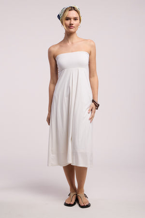 A woman stands against a plain background wearing the LUELLA SKIRT by Velvet by Graham & Spencer, styled with black flip-flops, a headscarf, and a bangle on her right wrist.
