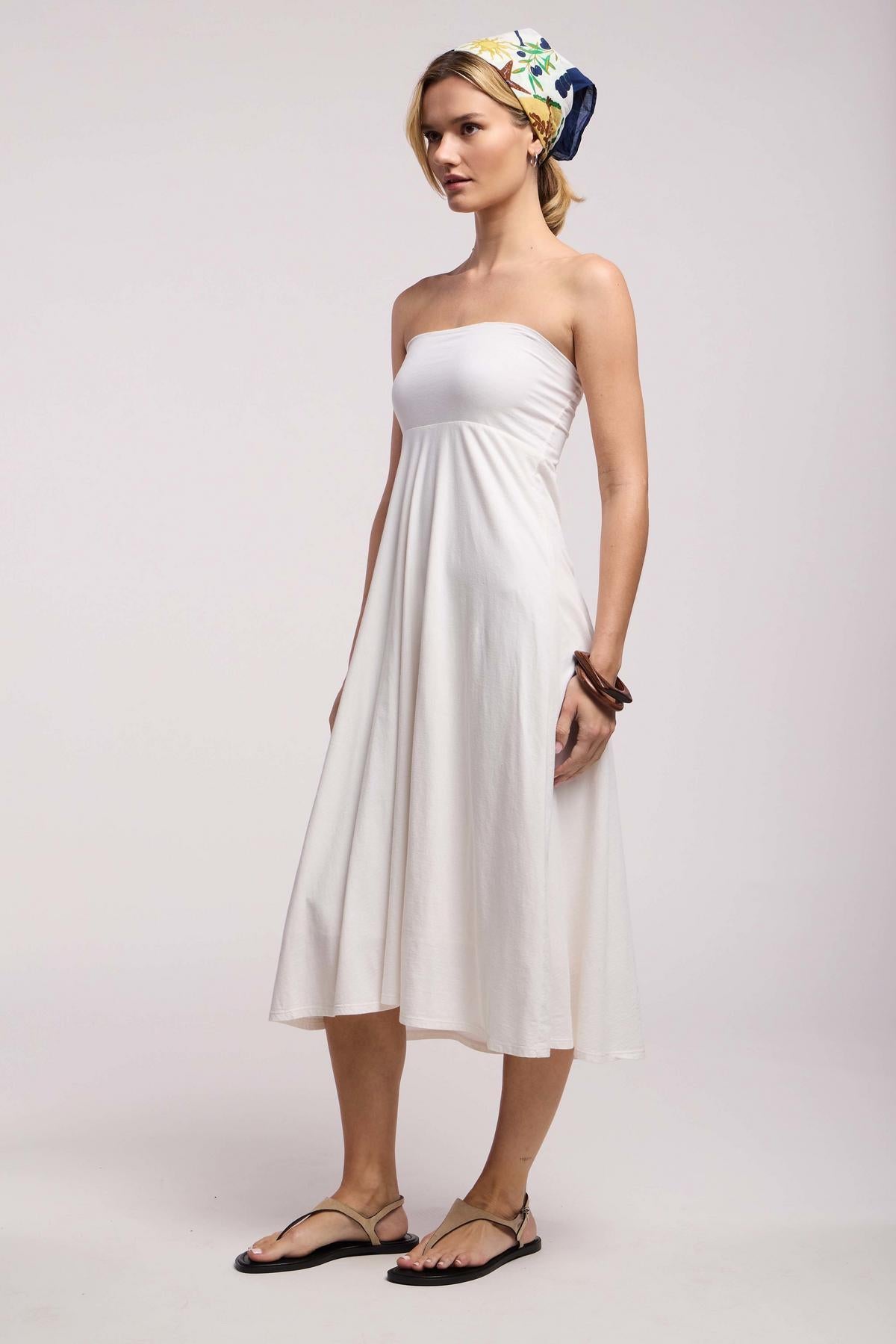 Woman in profile wearing the LUELLA SKIRT by Velvet by Graham & Spencer, styled with flat sandals, a printed headscarf, and a chunky bracelet against a plain background.-41548251037889