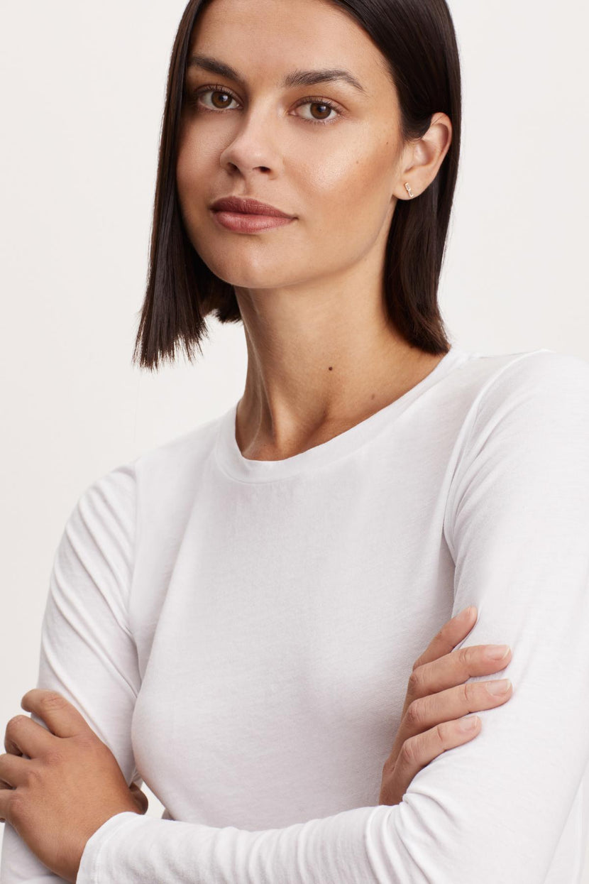 The model is wearing a Velvet by Graham & Spencer ZOFINA GAUZY WHISPER FITTED CREW NECK TEE.