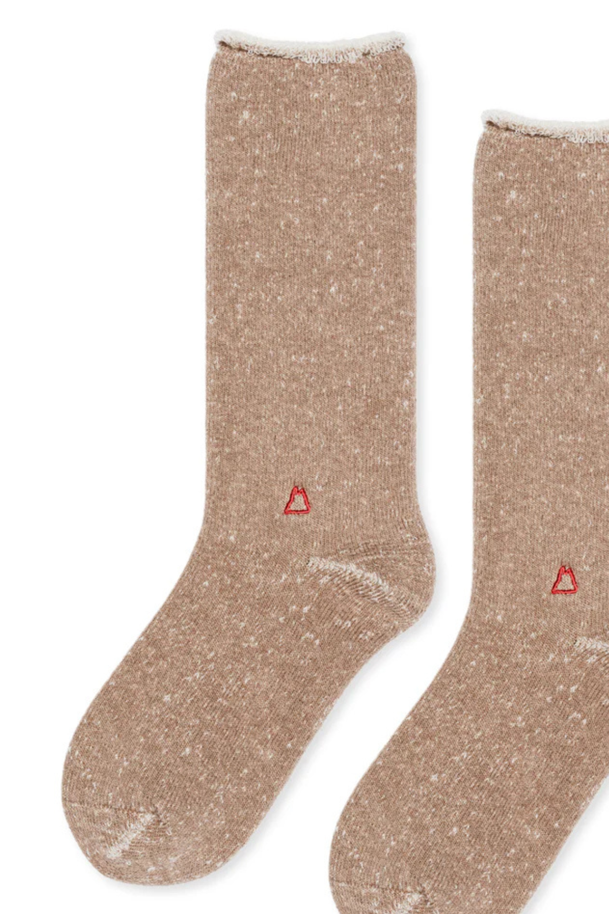   Two beige socks by Hansel From Basel, featuring a distinctive speckled pattern and a small red triangle logo near the toe on a white background. 