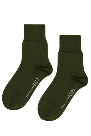 The TROUSER CREW SOCKS BY HANSEL FROM BASEL are dark green ankle socks made from mercerized cotton, featuring ribbed cuffs and a white logo with lettering on the sole by Hansel From Basel.