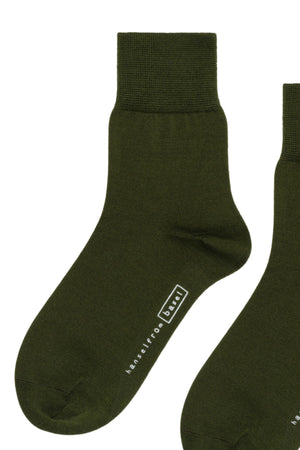 Upgrade your collection with Hansel From Basel's TROUSER CREW SOCKS, featuring two dark green socks made from luxurious mercerized cotton, a ribbed cuff, and an inscription on one sock for added style and comfort.