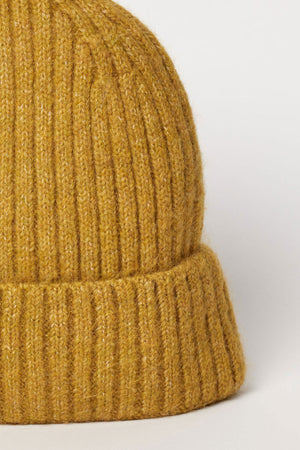 Close-up of the KEY BEANIE by Velvet by Graham & Spencer, featuring a mustard yellow ribbed knit and a folded brim, shown against a plain light background.
