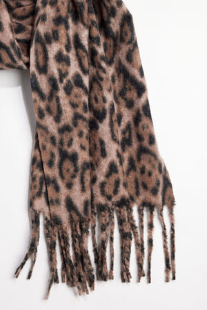 The LEOPARD SCARF by Velvet by Graham & Spencer, featuring a brown and black leopard print and fringed ends, is shown against a plain white background.