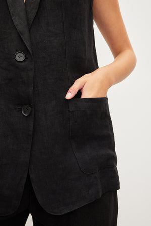 A woman wearing a Velvet by Graham & Spencer BETHAN HEAVY LINEN SLEEVELESS BLAZER.