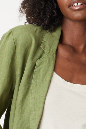 A woman wearing a green Velvet by Graham & Spencer CASSIE HEAVY LINEN BLAZER close up detail