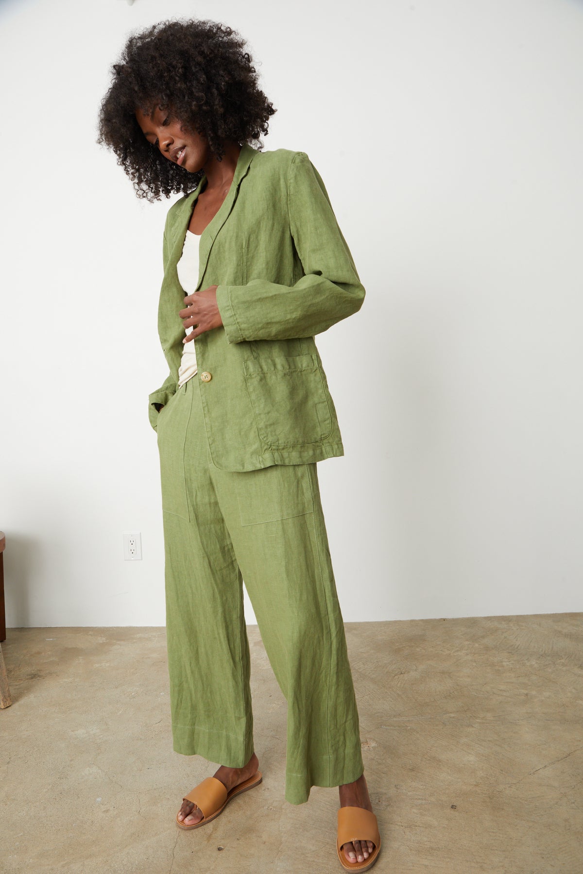 A woman wearing green linen pants and a Velvet by Graham & Spencer CASSIE HEAVY LINEN BLAZER with Dru pants full length front.-26757349048513