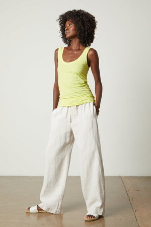 a black woman wearing a Velvet by Graham & Spencer MOSSY GAUZY WHISPER FITTED TANK and wide legged pants.