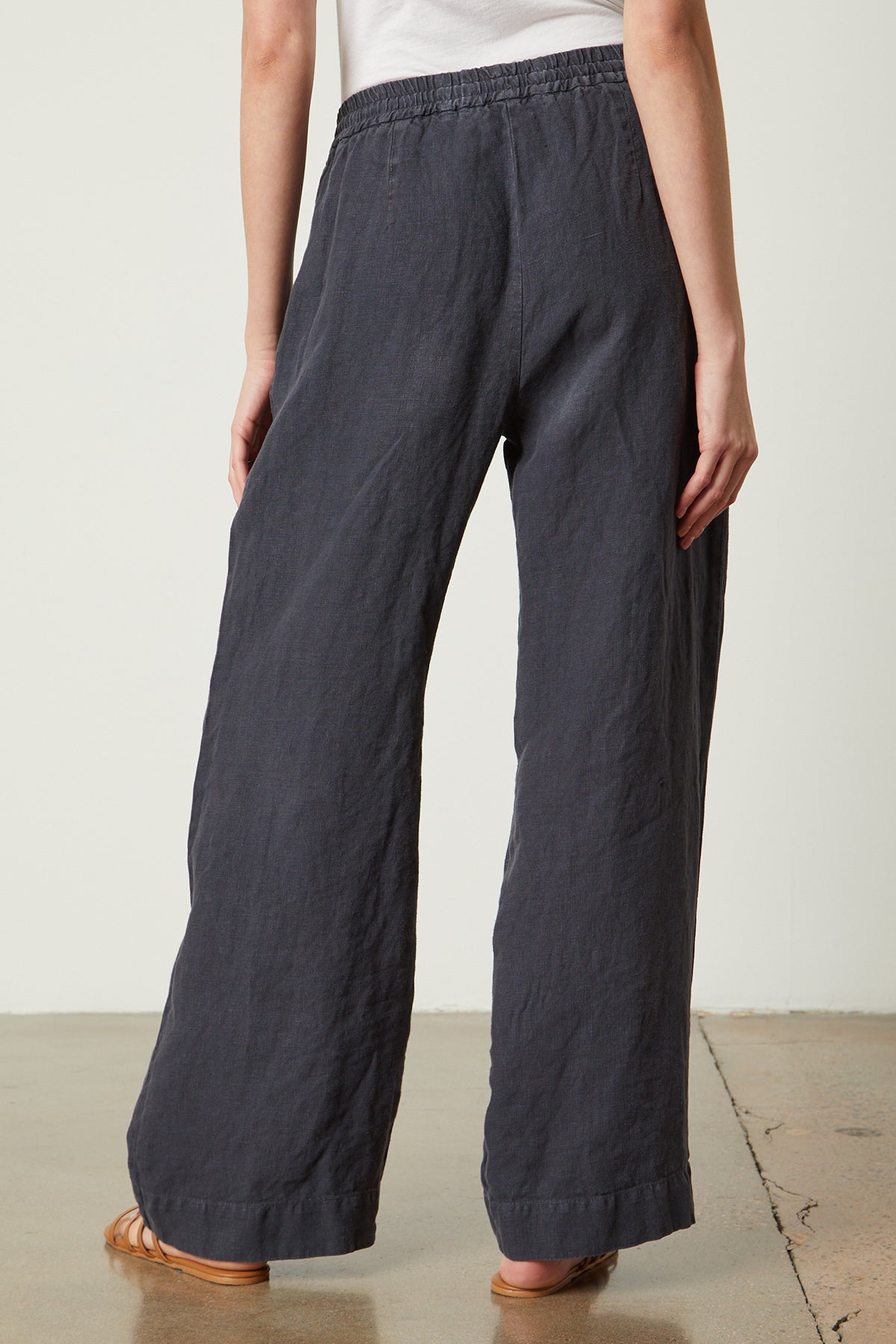 The back view of a woman wearing a pair of Velvet by Graham & Spencer GWYNETH HEAVY LINEN PANT wide leg pants.-35954253562049
