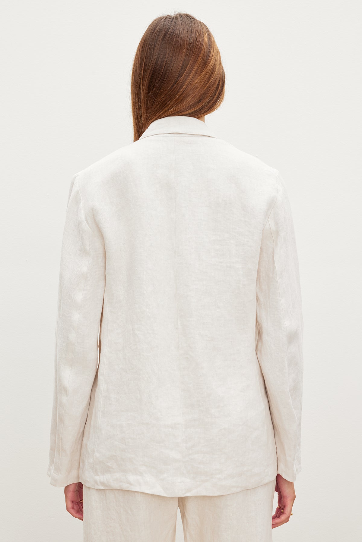 The back view of a woman wearing a Velvet by Graham & Spencer LENNY HEAVY LINEN BLAZER.-35982566457537