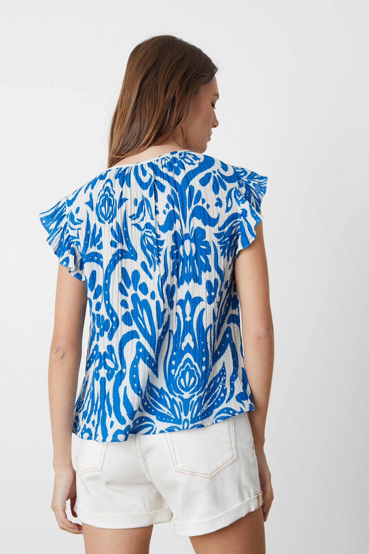 The back view of a woman wearing a Velvet by Graham & Spencer ALEAH PRINTED COTTON GAUZE TOP.-26342683443393