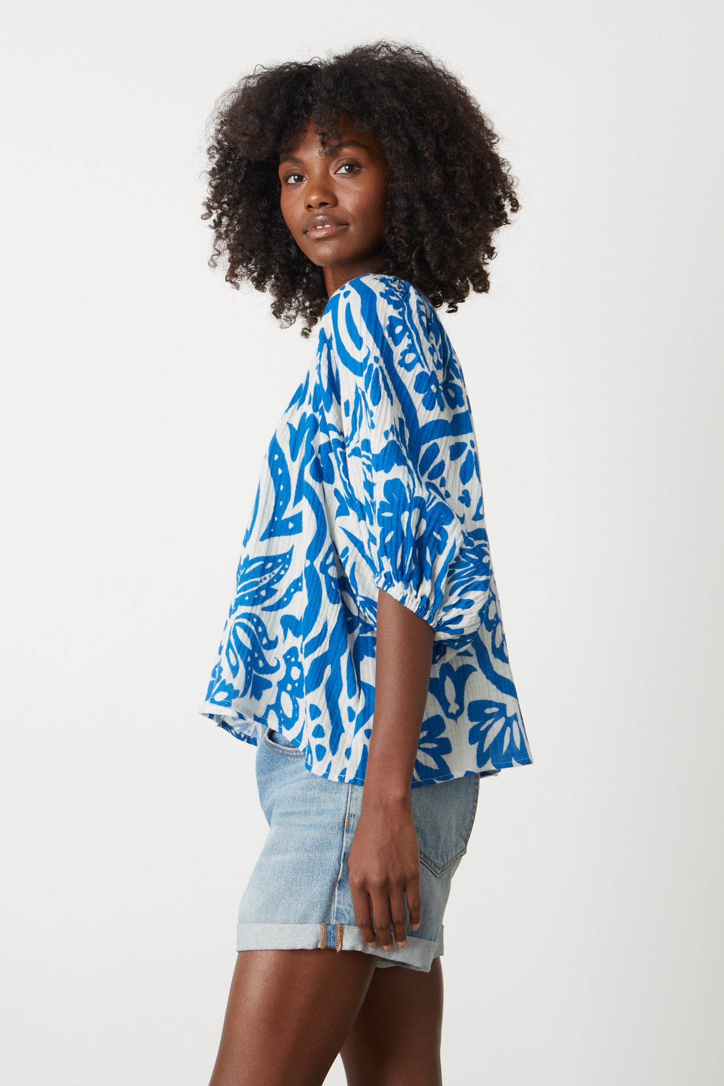 The model is wearing a Velvet by Graham & Spencer CANDICE PRINTED COTTON GAUZE TOP in blue and white floral.-26577386864833