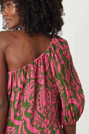 the back view of a woman wearing a Velvet by Graham & Spencer Gretchen printed one shoulder dress.