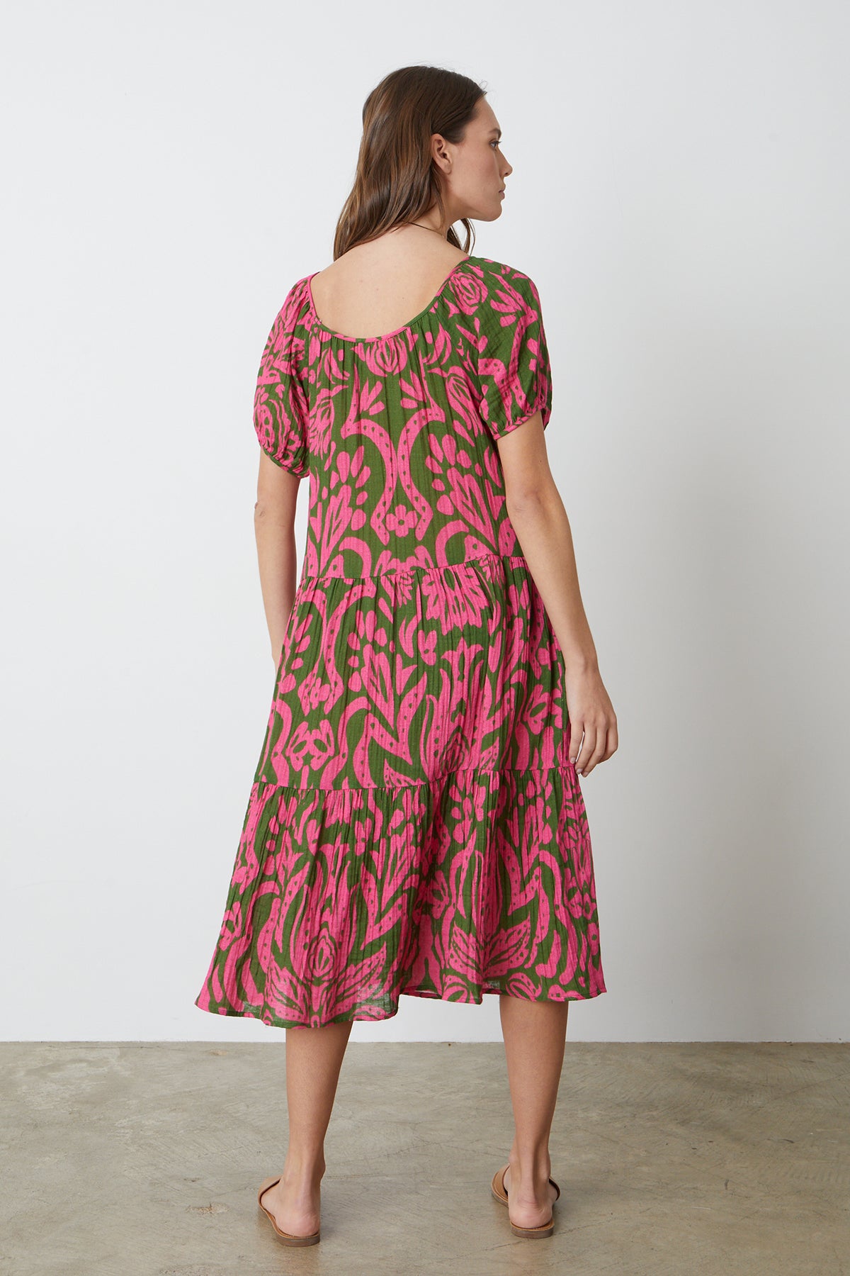 The back view of a woman wearing the Velvet by Graham & Spencer MADILYN PRINTED COTTON GAUZE MIDI DRESS in pink and green.-26342678397121