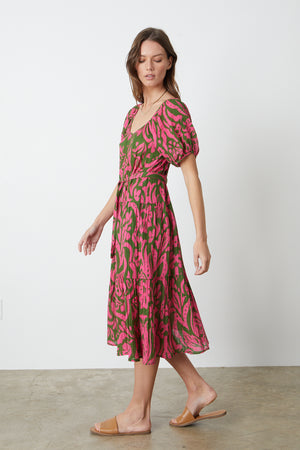 The model is wearing a Velvet by Graham & Spencer MADILYN PRINTED COTTON GAUZE MIDI DRESS in pink and green.
