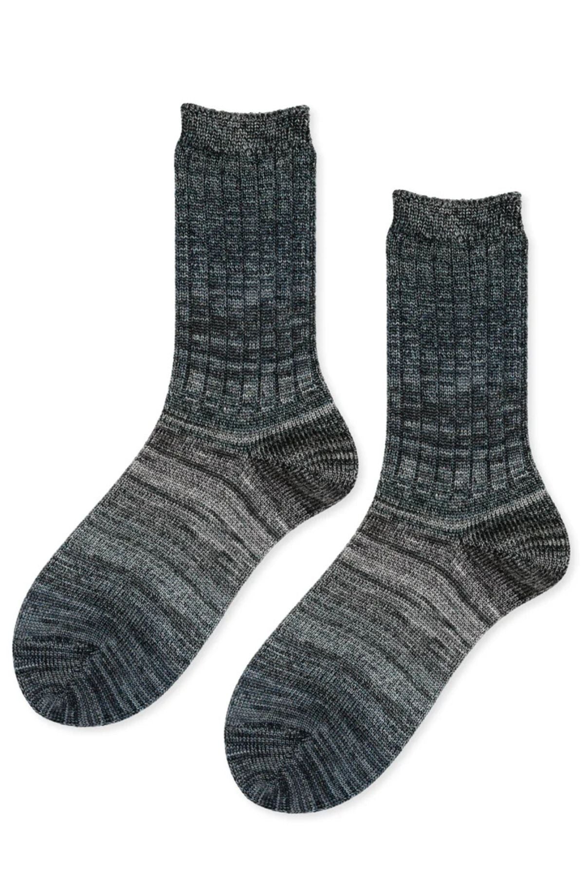 The COSMIC SPACE DYE MEN'S CREW SOCKS BY HANSEL FROM BASEL are dark grey ribbed crew socks with a gradient pattern and textured knit design, shown laid flat on a white background.