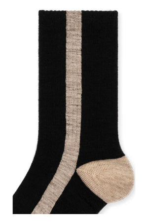 The TUXEDO STRIPE ATHLETIC WOOL CREW SOCK BY HANSEL FROM BASEL by Hansel From Basel is a black sock with a vertical beige stripe and a beige heel.