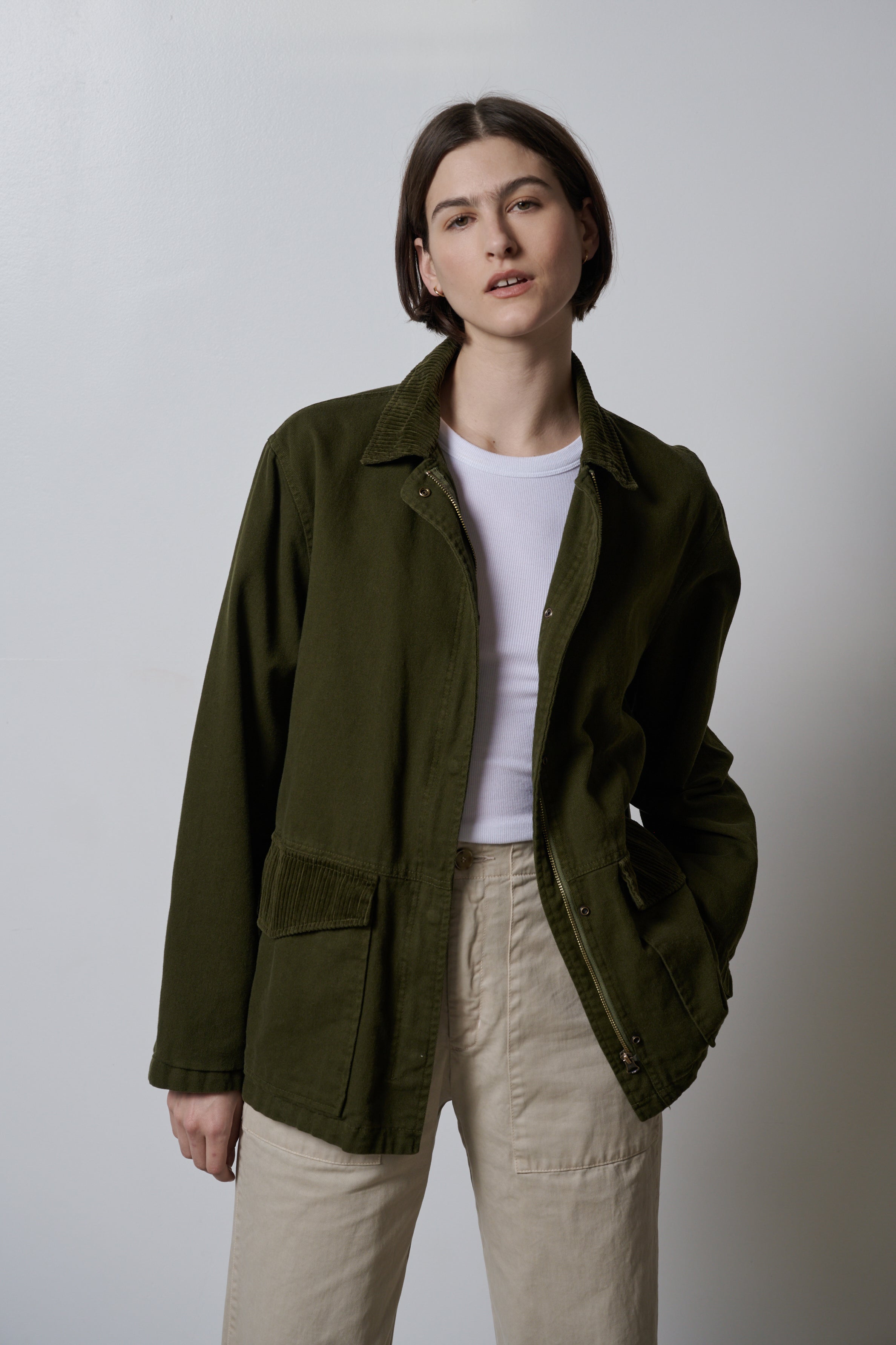   A model wearing a Velvet by Jenny Graham green OAKLEY JACKET and khaki pants made from cotton twill fabric. 