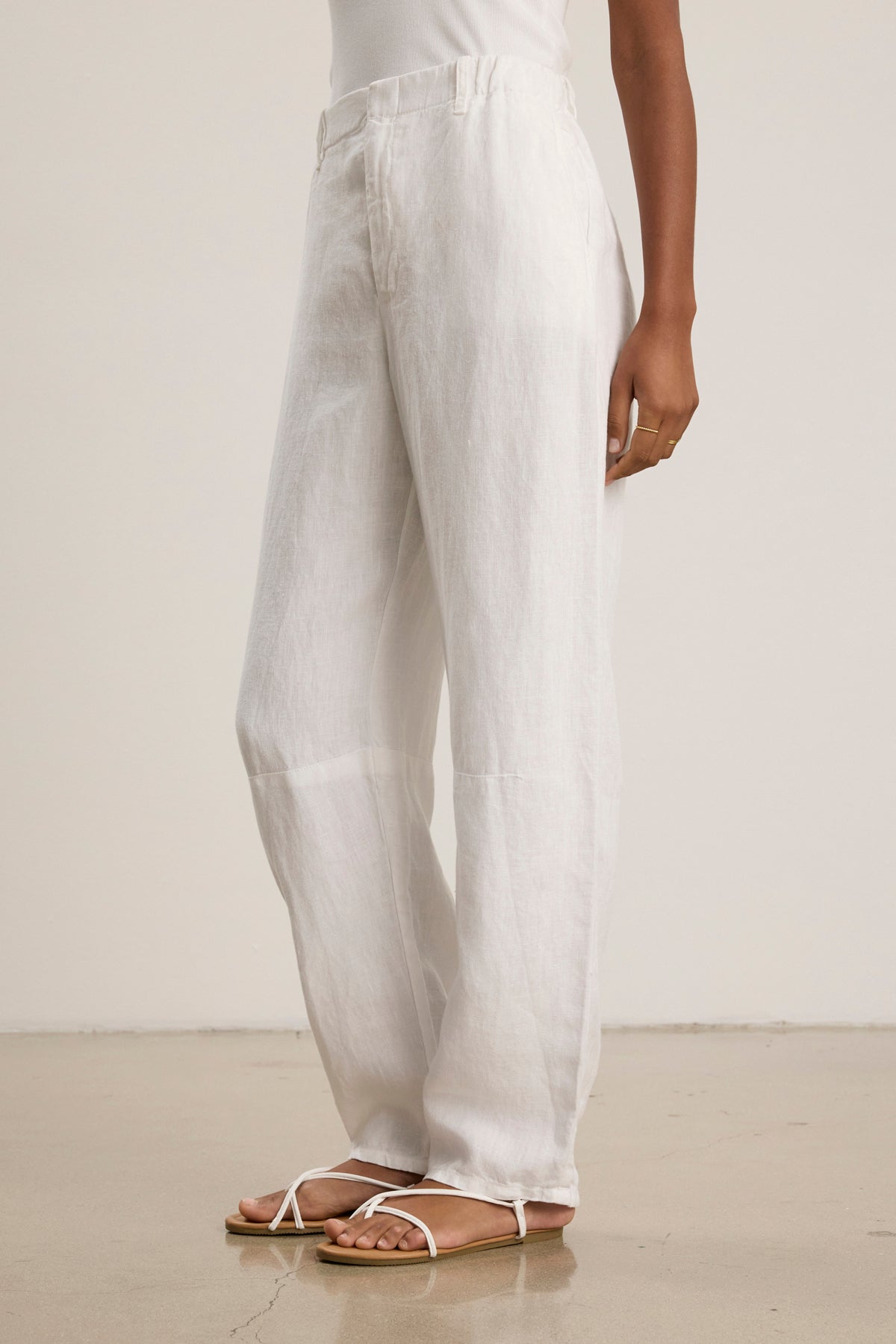 Model wears the TAYLOR HEAVY LINEN PANT from Velvet by Graham & Spencer, styled with a white sleeveless top and sandals, pictured on a polished floor against a plain background.-39111850295489